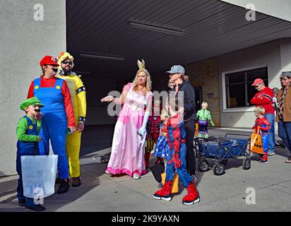 EMPORIA, KANSAS - 29 OTTOBRE 2022 persone con i loro figli vestiti in costume per il trucco di Halloween o trattare evento lungo la strada commerciale Foto Stock