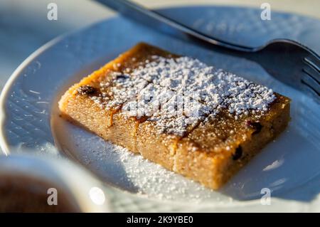 Una fetta di torta greca sotto la luce del sole da un ristorante greco locale Foto Stock