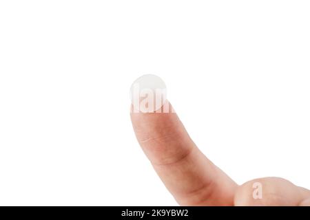 Chiudi-su cerotto rotondo dell'acne sul dito su fondo bianco. Cerotti acne per il trattamento di pimple e rosacea primo piano. Cosmo di pulizia del ringiovanimento facciale Foto Stock