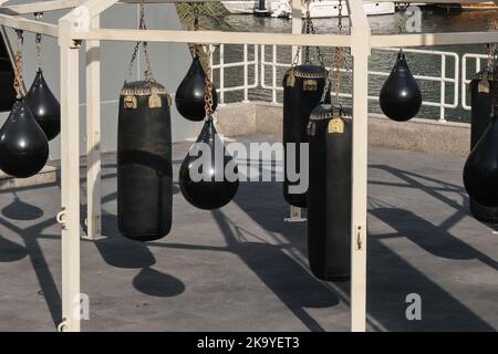Set di borse nere da punzonatura, pere da boxe per kickboxing ed esercizi di fitness. Centro fitness all'aperto con borse da punzonatura Foto Stock