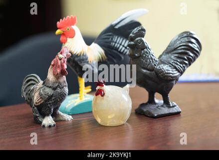 Collezione di statuette di pollo in cima a una scrivania Foto Stock