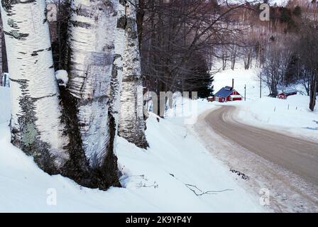 Una casa di zucchero acero si trova alla fine di una strada tortuosa nella campagna rurale del Vermont, New England in inverno Foto Stock