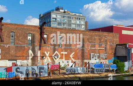 Graffiti lungo l'East River Waterfront sotto un edificio di loft a Brooklyn, New York, USA. Foto Stock