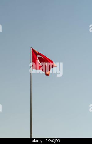 Bandiera nazionale della Turchia con stella bianca e mezzaluna che ondola contro il cielo blu nelle giornate di sole Foto Stock