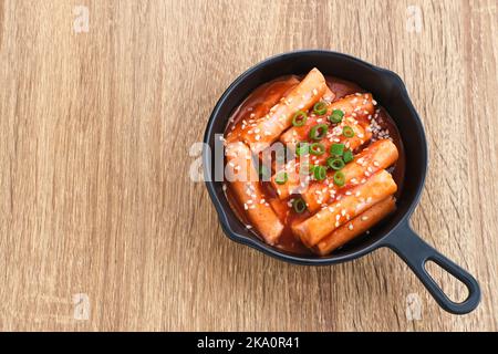 Tteokbokki o Topokki , bastoncino di torta di riso fritto mescolato, popolare cibo di strada coreano con salsa piccante gochujang e semi di sesamo. Foto Stock