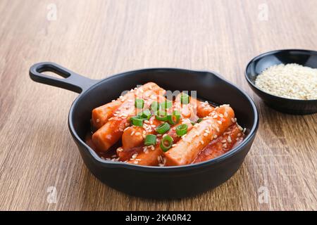 Tteokbokki o Topokki , bastoncino di torta di riso fritto mescolato, popolare cibo di strada coreano con salsa piccante gochujang e semi di sesamo. Foto Stock