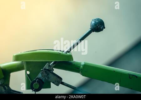 La leva di comando su un trattore con operatore a distanza ravvicinata su uno sfondo sfocato. Elementi di controllo di macchine agricole. Foto Stock