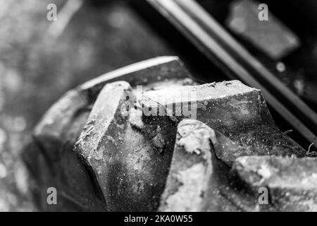 Battistrada in gomma volumetrico su un primo piano delle ruote del trattore. Modello di pneumatico fango per una maggiore capacità di cross-country sulle macchine agricole, pho bianco e nero Foto Stock