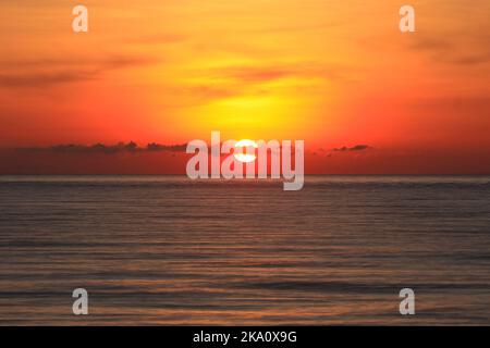 Un'immagine di un bel tramonto rosso con un grande sole giallo Foto Stock