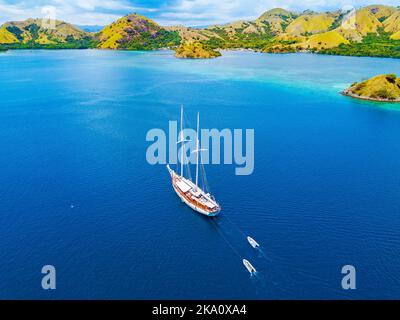 Vista panoramica di un bellissimo paesaggio sull'isola di Flores con yatch turistico, turqouise e mare blu scuro. Foto Stock