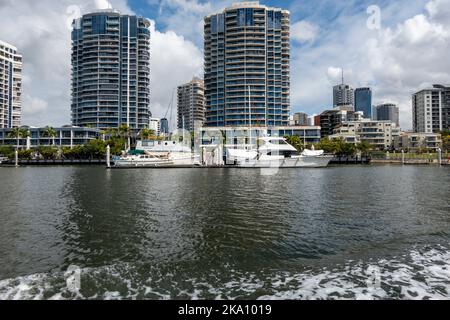 Brisbane, Queensland, Australia - Agosto 2022: Alti alberghi e appartamenti in affitto sulle rive del fiume Brisbane con barche di lusso ormeggiate vicino alla riva Foto Stock