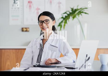 Come posso aiutarla oggi. Ritratto corto di una giovane dottoressa che lavora nel suo ufficio in ospedale. Foto Stock