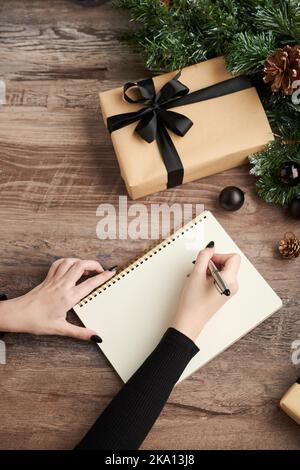 Immagine di primo piano della lettera di scrittura della donna da allegare al regalo di Natale Foto Stock
