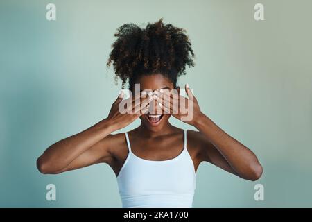 Mostra il tuo fro, non nascondendo più la tua bellezza naturale. Studio shot di una bella, fresca di fronte giovane donna in posa su uno sfondo verde. Foto Stock