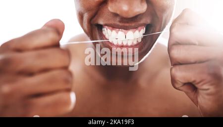 Ricordati sempre di passare regolarmente il filo: Un giovane irriconoscibile che gli ha fatto passare i denti in bagno a casa. Foto Stock