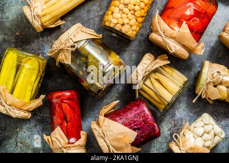 Conservazione di vegetali in vasetti di vetro. Pomodori, cetrioli, funghi, cavolo, pepe Foto Stock