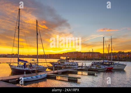 Preston. UK Weather, 31 Ott 2022. Un caldo inizio di sole alla giornata nel nord-ovest come il sole sorge sopra Preston Docks. Le temperature miti continuano mentre i residenti locali godono di una leggera attività fisica lungo il Riverside Walk, parte della Navigation Way nei Docklands. Credit; MediaWorldImages/AlamyLiveNews Foto Stock