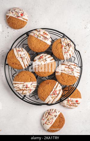 Biscotti di Natale con glassa bianca e spolverini per le vacanze Foto Stock