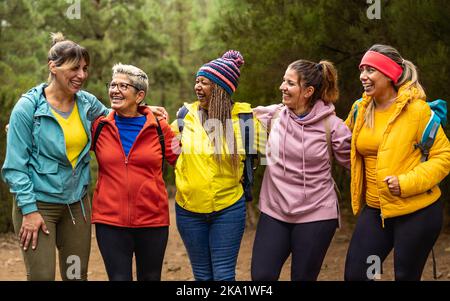 Donne felici con età ed etnie differenti che si divertono nei boschi - concetto di gente di viaggio e di avventura Foto Stock