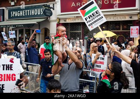 Londra, Regno Unito. Luglio 19, 2014. Un uomo tiene un bambino in alto durante una marcia contro le azioni israeliane contro la Palestina. Foto Stock