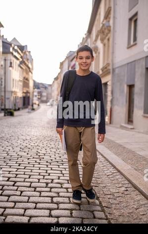 Ragazzi allegri passeggiando lungo la strada cittadina Foto Stock