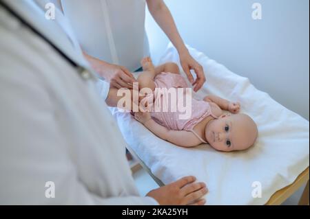 Chirurgo che controlla le gambe delle bambine per la displasia Foto Stock