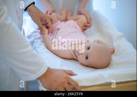 Chirurgo che controlla le gambe delle bambine per la displasia Foto Stock