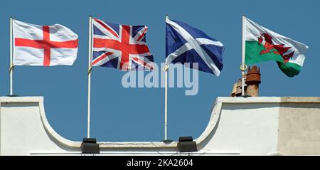 Weston Super Mare Union flag & English Welsh Scottish Flags volare insieme dalla parte superiore dell'edificio con Union Jack il modo sbagliato di up Inghilterra UK Foto Stock