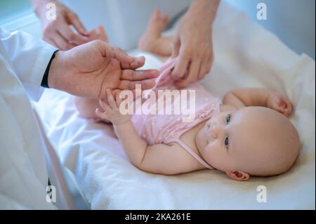 Chirurgo che controlla le gambe delle bambine per la displasia Foto Stock