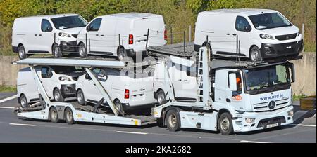 Nuovi furgoni bianchi Peugeot Expert caricati e trasportati da rimorchi articolati e autocarri hgv su autostrada del Regno Unito Foto Stock