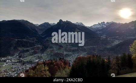 Un bel colpo di sole coperto da un sottile strato di nube sulle colline rocciose Foto Stock