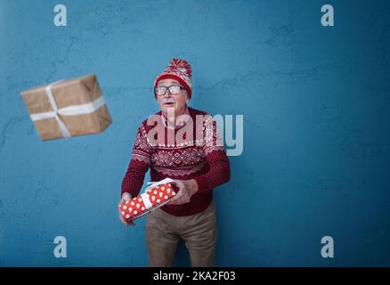 Ritratto di felice uomo anziano cattura regalo, studio di ripresa. Foto Stock