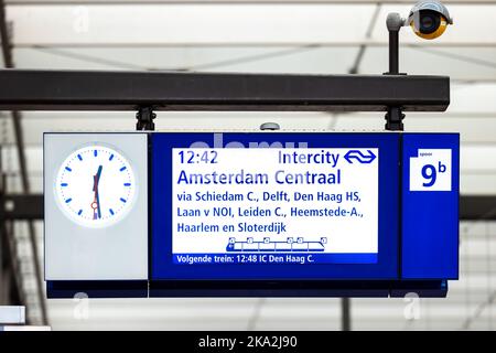 Stazione ferroviaria centrale di Amsterdam, Paesi Bassi. Schermata di visualizzazione dell'orario del treno alla stazione ferroviaria centrale nel centro di Amsterdam. Cartello blu con orologio Foto Stock