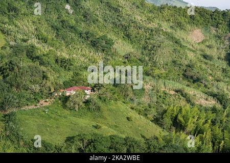 Bellissimo paesaggio in una zona rurale colombiana, con una casa contadina circondata da pascoli e coltivazioni di canna da zucchero, fatta sul lato di una montagna. Gineb Foto Stock