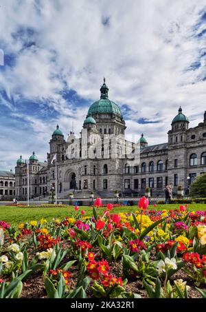 Uno scatto verticale del British Columbia Parliament Building e un giardino frontale con fiori di tulipano Foto Stock