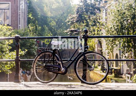 Una sola bicicletta su un ponte su un canale in Utrecht, Paesi Bassi Foto Stock