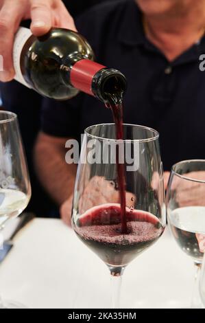 Bottiglia di vino rosso di Rioja che serve una tazza Foto Stock