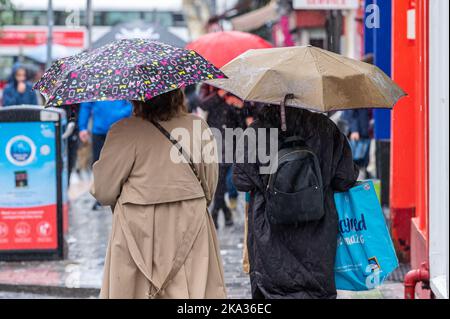 Cork, Irlanda. 31st Ott 2022. Met Éireann ha pubblicato un Orange Weather Warning per la pioggia in 4 contee oggi. Oggi pomeriggio a Cork è caduta una pioggia torrenziale, mentre le persone si sono accoccolate sotto gli ombrelloni. Più piogge e inondazioni localizzate sono previste più tardi questa sera. Credit: AG News/Alamy Live News Foto Stock