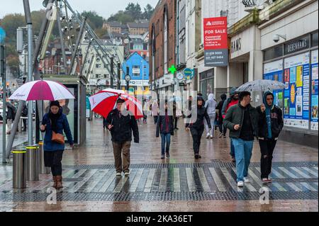 Cork, Irlanda. 31st Ott 2022. Met Éireann ha pubblicato un Orange Weather Warning per la pioggia in 4 contee oggi. Oggi pomeriggio a Cork è caduta una pioggia torrenziale, mentre le persone si sono accoccolate sotto gli ombrelloni. Più piogge e inondazioni localizzate sono previste più tardi questa sera. Credit: AG News/Alamy Live News Foto Stock