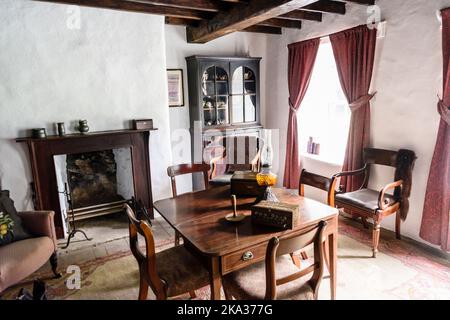Sala da pranzo all'interno di una fattoria irlandese del 19th ° secolo 1800s con mobili. Foto Stock