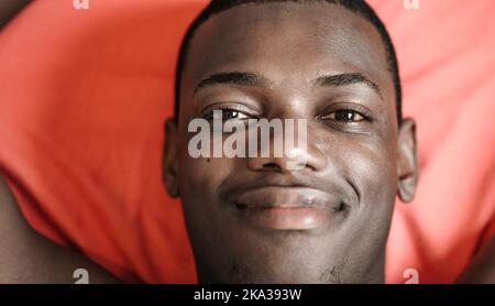 Felice uomo nero su coperta rossa Foto Stock