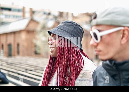 Giovane coppia multietnica sorridente per strada. Foto Stock