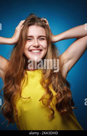 donna felice con capelli ricci sani forti Foto Stock
