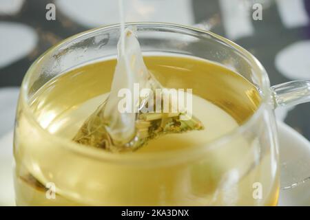 Foglie di tè asciutte in una bustina di tè in tazza da tè Foto Stock