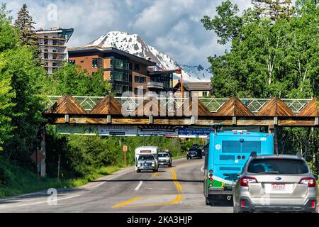 Aspen, USA - 27 giugno 2019: Snowmass Village, una piccola località sciistica del Colorado con vista sulle montagne innevate e autobus auto in strada stradale o Foto Stock