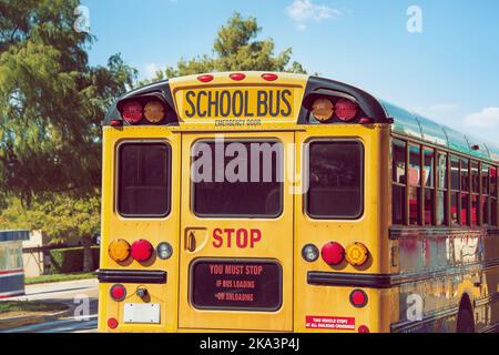 Vista posteriore di un scuolabus giallo. Concetto di ritorno a scuola. Foto Stock