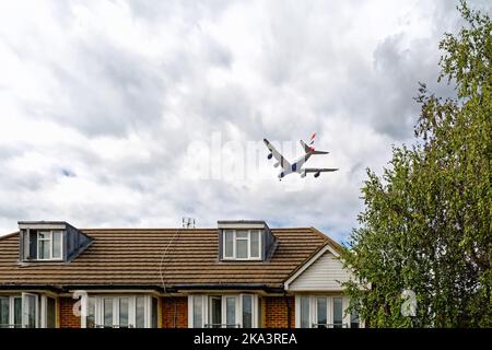 Un aereo passeggeri super jumbo della British Airways A380 che vola a bassa altitudine sopra le case suburbane a Hounslow, sull'IT's Approach to Heathrow Airport UK Foto Stock