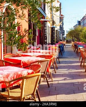 Tavoli con panni rossi sulla terrazza all'aperto del ristorante sulla strada turistica, Gyor, Ungheria Foto Stock