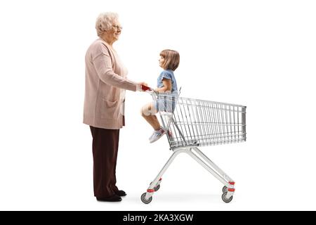 Profilo a tutta lunghezza girato di nonna con un bambino in un carrello isolato su sfondo bianco Foto Stock
