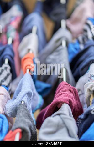 Un primo piano verticale di calze colorate sulla corda di lavaggio. Messa a fuoco selezionata. Foto Stock